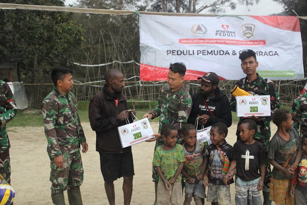 Satgas Yonif Mekanis 203AK Bagikan Sarana Olahraga kepada Pemuda Desa Tima